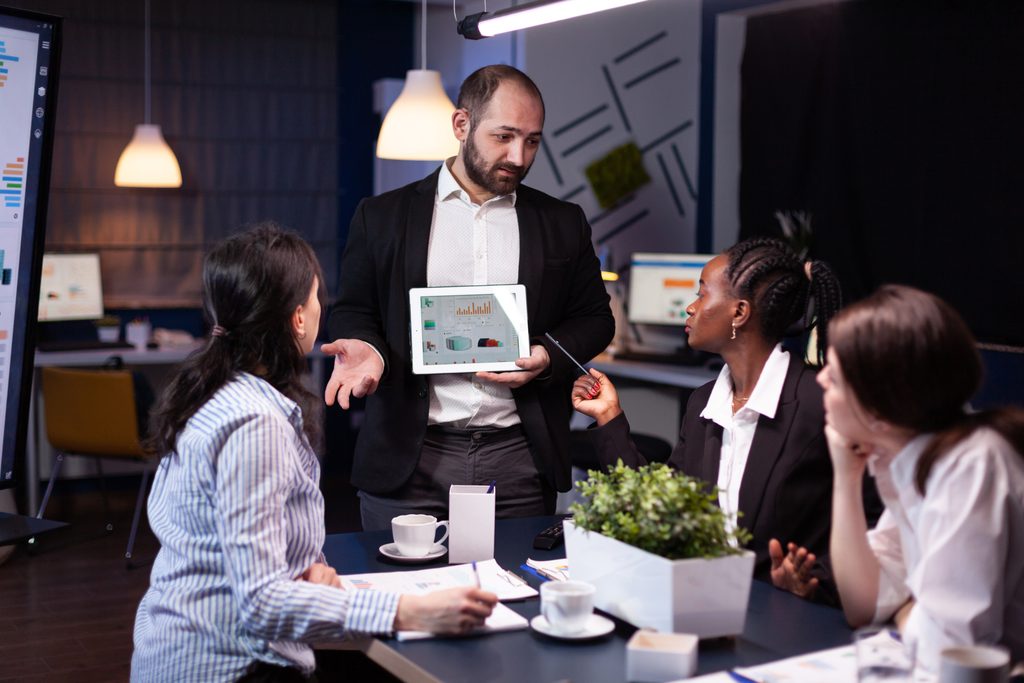 How Businesses Can Turn Technology Into a Competitive Advantage | thenewsmedium.com 2 overworked businessman showing financial graphs presentation using tablet brainstorming company ideas